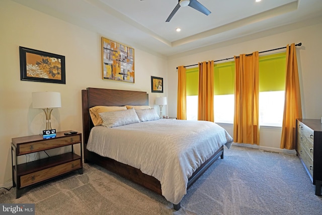 bedroom with ceiling fan, a raised ceiling, and carpet