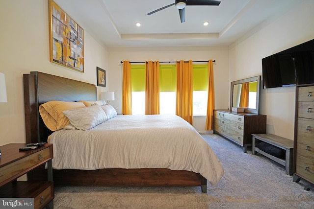 bedroom featuring a raised ceiling, ceiling fan, and carpet floors