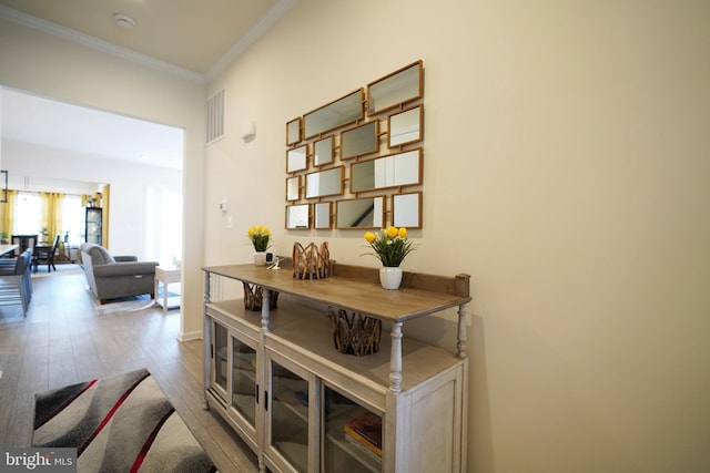 interior space featuring wood-type flooring and ornamental molding