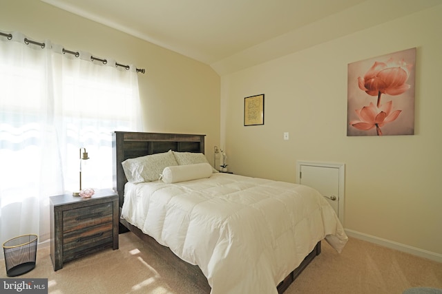 bedroom featuring light carpet and vaulted ceiling