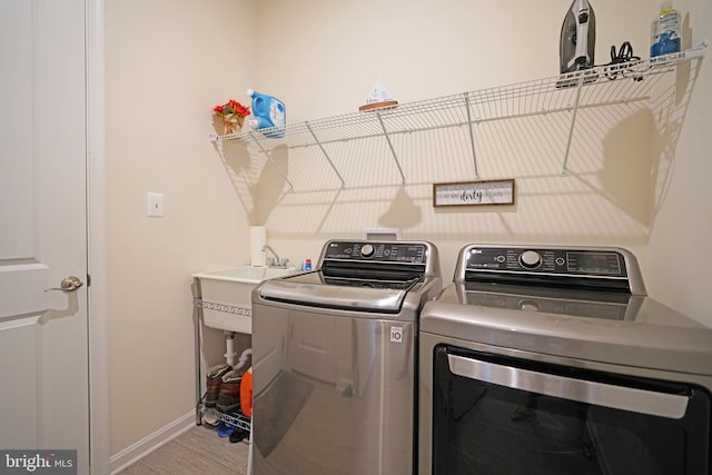 washroom with independent washer and dryer and sink