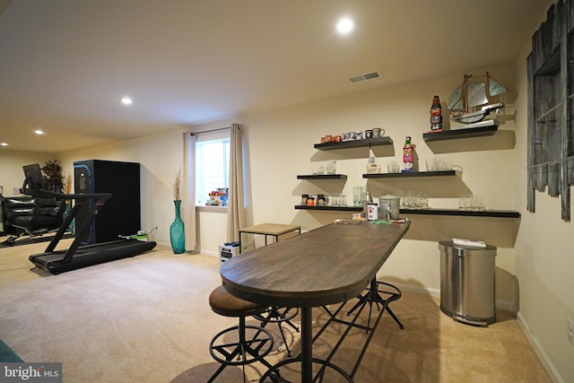 interior space featuring light carpet and bar area