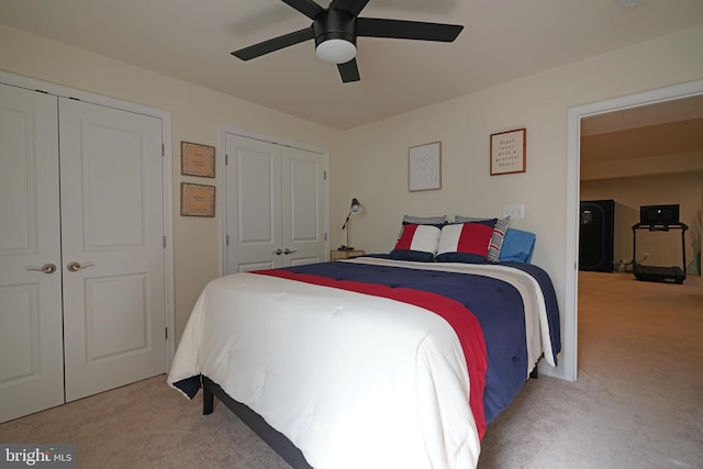 bedroom with two closets, ceiling fan, and carpet floors