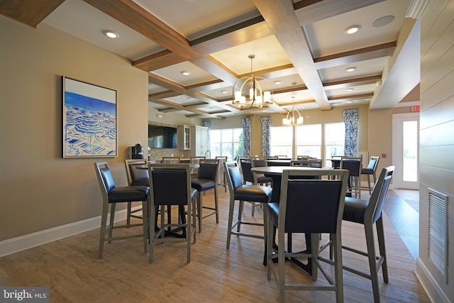 dining area featuring beamed ceiling, hardwood / wood-style floors, a chandelier, and coffered ceiling