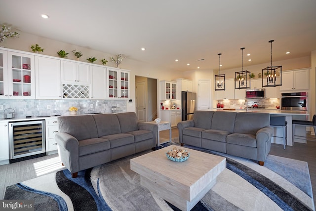 living room featuring dark hardwood / wood-style flooring, beverage cooler, and sink