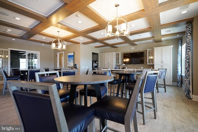 dining area featuring light hardwood / wood-style flooring, coffered ceiling, beamed ceiling, and a chandelier