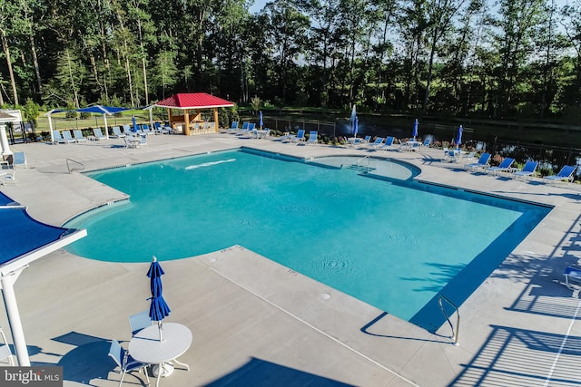 view of pool with a water view and a patio area