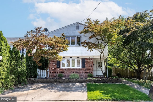 view of front of house with fence and brick siding