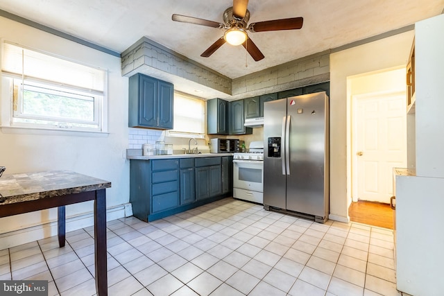 kitchen featuring gas range gas stove, stainless steel fridge with ice dispenser, sink, light tile patterned floors, and ceiling fan