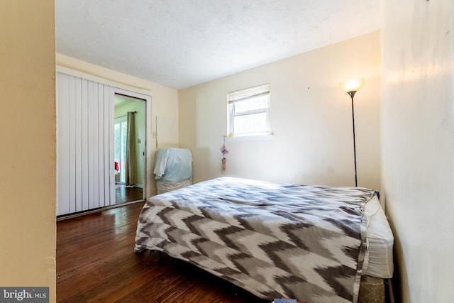 bedroom featuring a textured ceiling and dark wood-type flooring