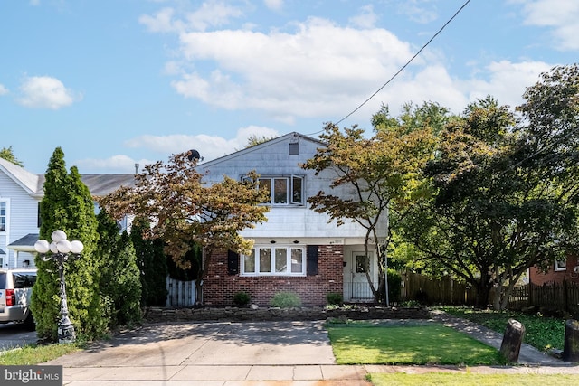 view of front of house with fence and brick siding