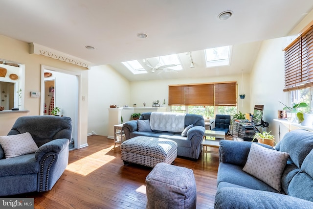 living room featuring vaulted ceiling with skylight and dark hardwood / wood-style flooring