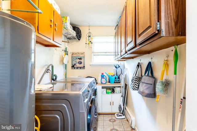 clothes washing area with cabinets, light tile patterned floors, washer and clothes dryer, and a textured ceiling