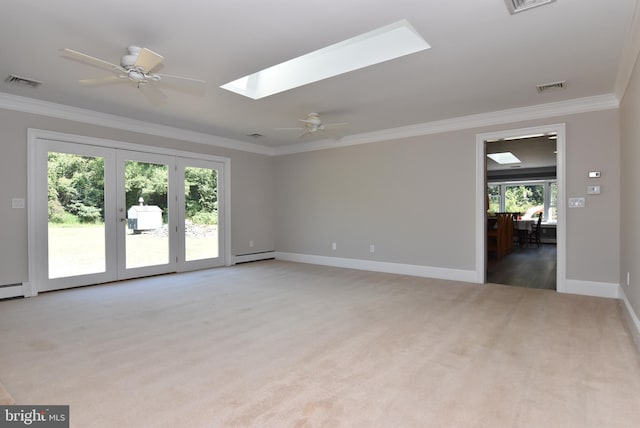 carpeted empty room featuring a skylight, ceiling fan, and ornamental molding