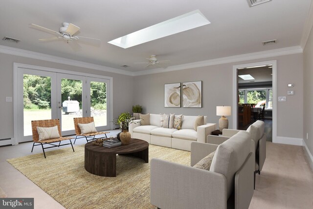 living room featuring ceiling fan, ornamental molding, light carpet, and a skylight