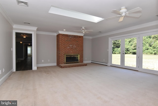 unfurnished living room with visible vents, a fireplace, a skylight, and crown molding