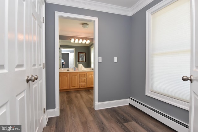 bathroom featuring ornamental molding, wood finished floors, baseboards, baseboard heating, and vanity