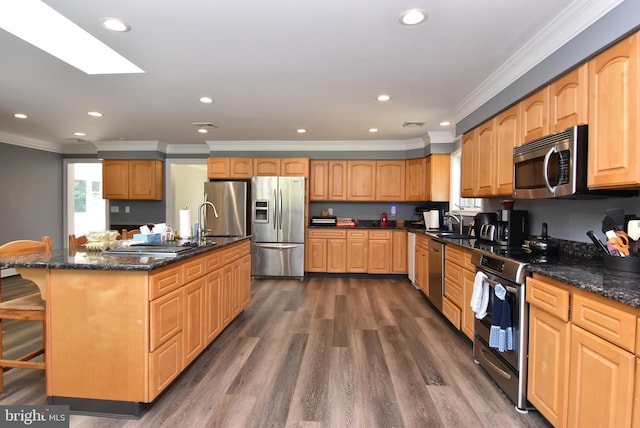 kitchen with a sink, dark stone counters, ornamental molding, appliances with stainless steel finishes, and dark wood-style flooring