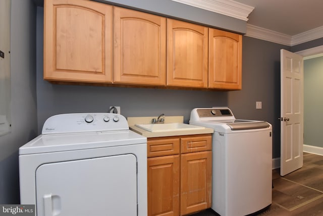 clothes washing area with dark wood-style floors, cabinet space, a sink, crown molding, and washer and clothes dryer