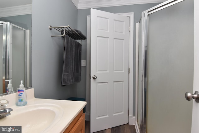 bathroom featuring ornamental molding, vanity, wood-type flooring, and walk in shower