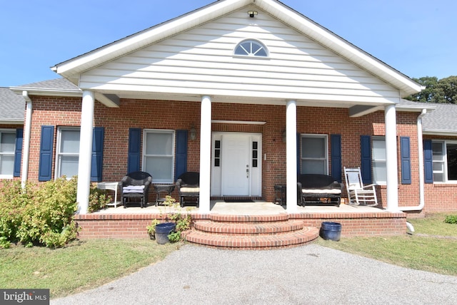 view of front of house featuring brick siding and a porch