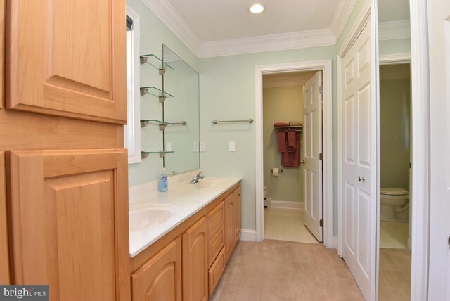 bathroom with crown molding, vanity, toilet, and tile patterned floors