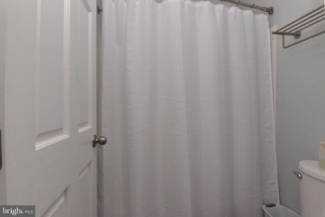 bathroom featuring toilet and a shower with shower curtain