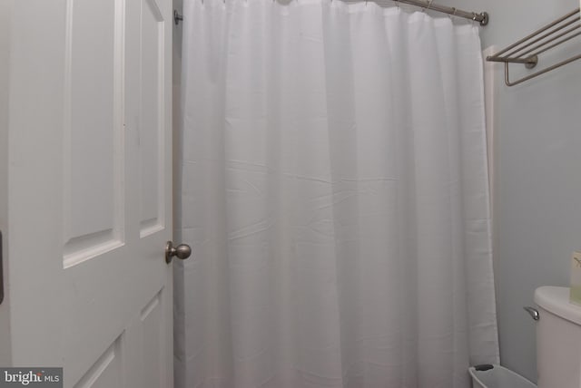 full bathroom featuring toilet and a shower with shower curtain