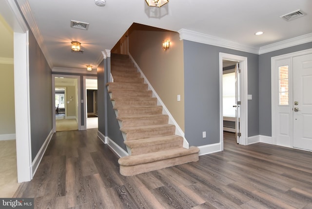 entryway featuring stairs, wood finished floors, visible vents, and ornamental molding