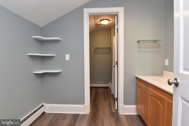 bathroom featuring a baseboard heating unit, lofted ceiling, and hardwood / wood-style flooring