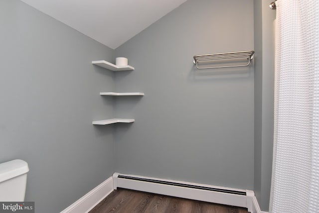 interior space with a baseboard radiator, dark hardwood / wood-style flooring, and vaulted ceiling