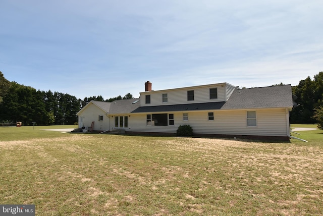 rear view of property with a lawn and a chimney