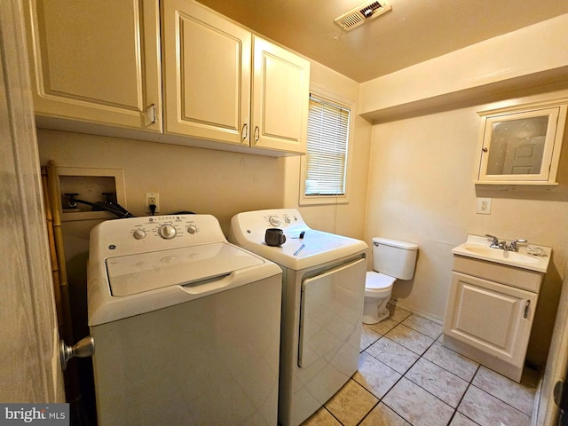 laundry area featuring visible vents, a sink, light tile patterned flooring, laundry area, and washing machine and clothes dryer