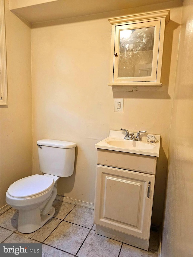 bathroom featuring tile patterned flooring, toilet, vanity, and baseboards