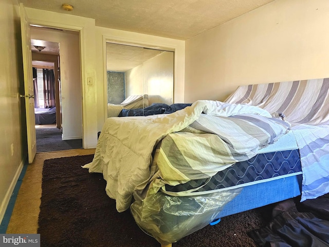 bedroom with a closet, baseboards, and carpet