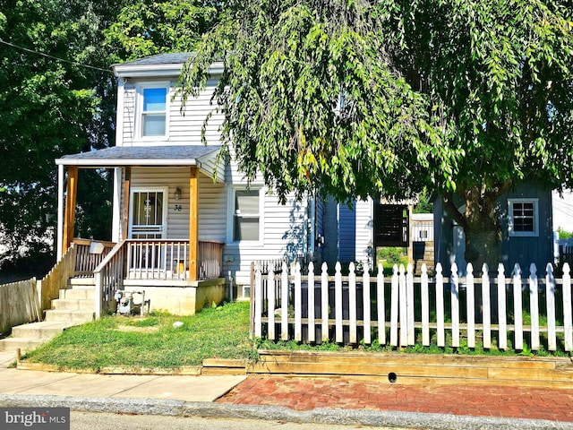 view of front of property with a fenced front yard, a porch, and a shingled roof