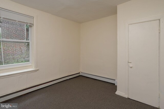 spare room with a baseboard heating unit and carpet flooring