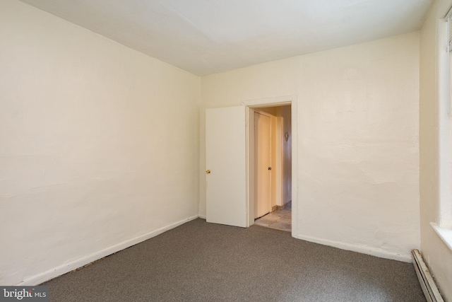 carpeted spare room featuring a baseboard heating unit