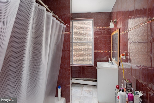 bathroom featuring vanity, a baseboard radiator, tile walls, and walk in shower