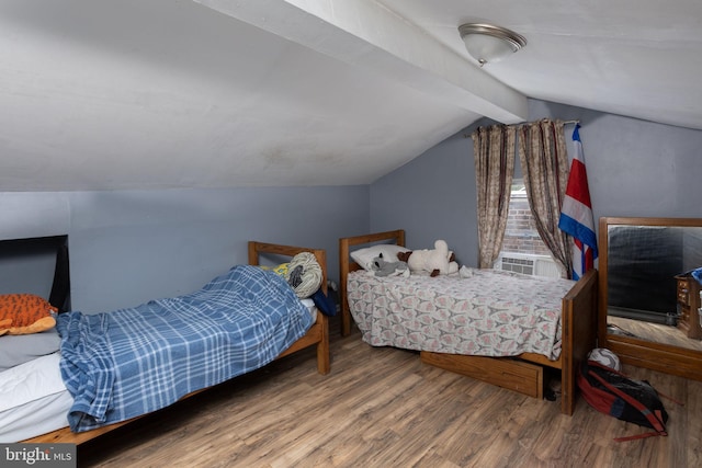 bedroom with cooling unit, hardwood / wood-style flooring, and vaulted ceiling