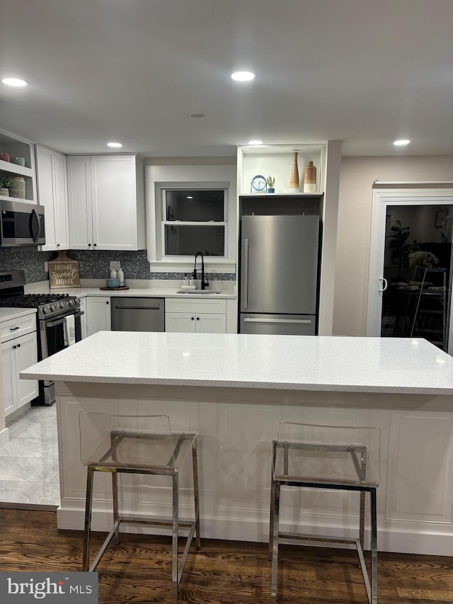 kitchen featuring dark hardwood / wood-style floors, white cabinetry, sink, and stainless steel appliances