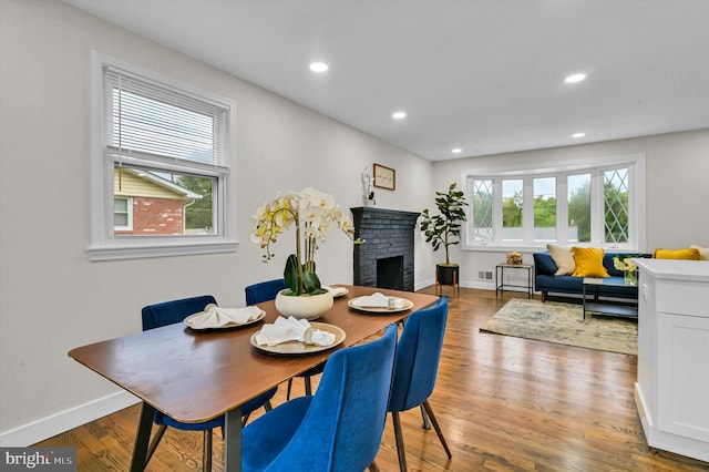 dining room featuring hardwood / wood-style flooring and a fireplace