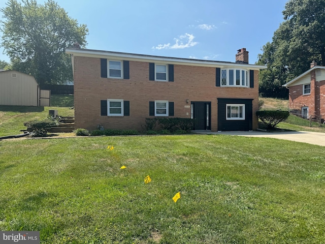 view of front of home with a front lawn and a shed