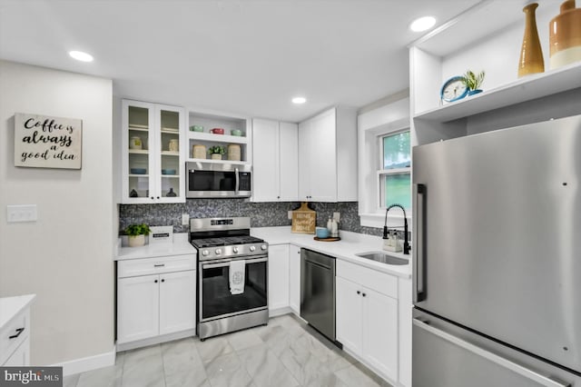 kitchen with stainless steel appliances, backsplash, sink, and white cabinetry