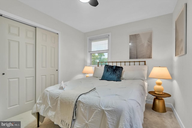 carpeted bedroom with ceiling fan and a closet