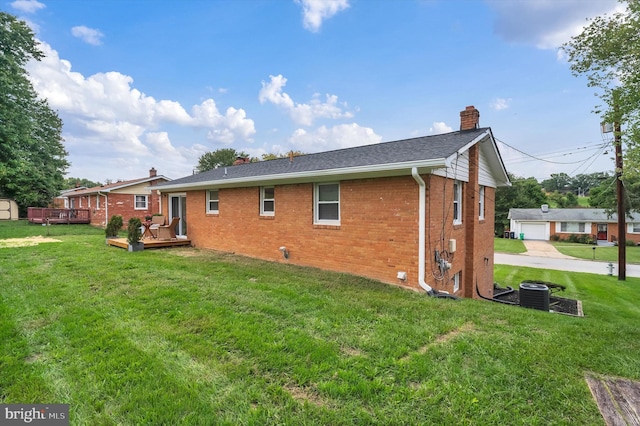 back of house with cooling unit, a yard, and a deck