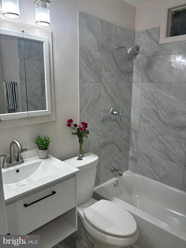 full bathroom featuring tiled shower / bath, vanity, and toilet