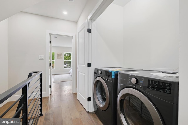 laundry area featuring washer and clothes dryer and light hardwood / wood-style floors