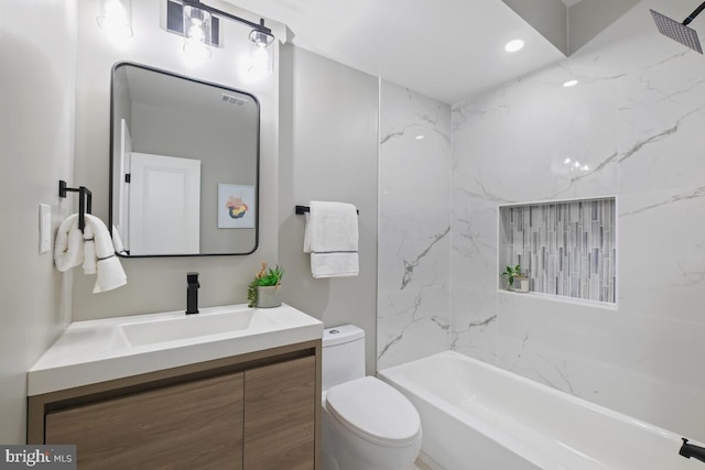 full bathroom featuring vanity, tiled shower / bath combo, and toilet