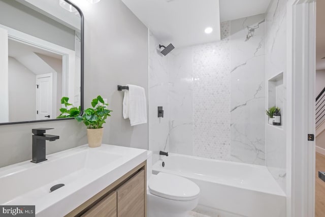 full bathroom with tiled shower / bath, vanity, and toilet